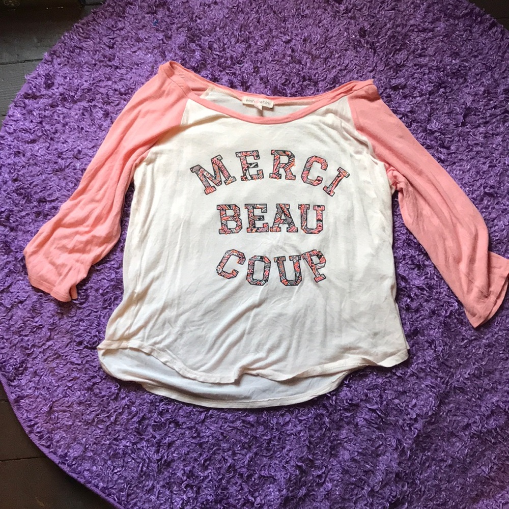 A shirt says MERCI BEAU COUP
